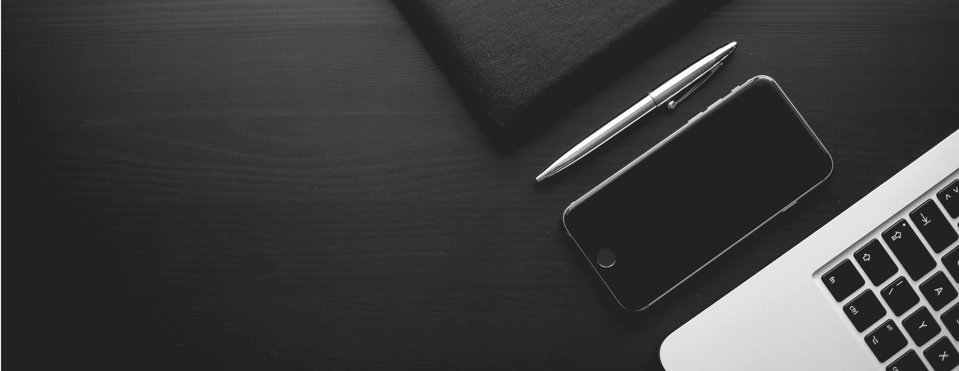 phone, laptop and pen on an office desk of digital agency